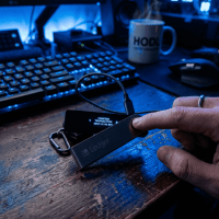 Ledger hardware wallet displaying bitcoin transaction confirmation while finger presses button